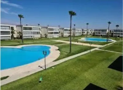 two swimming pools in an apartment complex with palm trees at La cascade 2 in Sidi Rahal