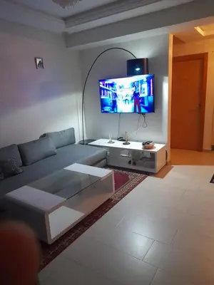 a living room with a couch and a flat screen tv at La cascade 2 in Sidi Rahal