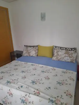 a bed with a floral bedspread and pillows on it at La cascade 2 in Sidi Rahal