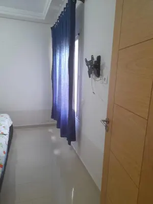 a room with a blue curtain and a window at La cascade 2 in Sidi Rahal