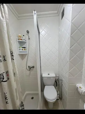 a white bathroom with a toilet and a shower at Un charmant Studio Meublé a Casablanca Maarif in Casablanca