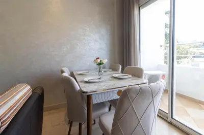 a dining room with a table and chairs and a window at NEW - 2CH Val d'Anfa Triangle d'Or - Fibre Optique in Casablanca