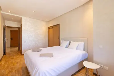 a bedroom with a large white bed with a table at NEW - 2CH Val d'Anfa Triangle d'Or - Fibre Optique in Casablanca