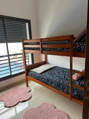 a bedroom with two bunk beds and a window at Appartement calme in Bouznika