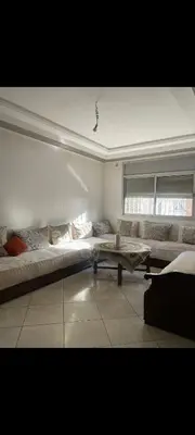 a living room with a large bed and a table at Sidi rahal apartment in Sidi Rahal