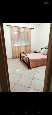 a bedroom with a bed with pink sheets and a window at Sidi rahal apartment in Sidi Rahal