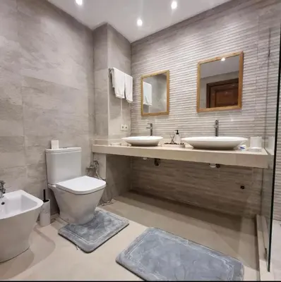 a bathroom with two sinks and a toilet at Modern gated apartment 2 bedroom 2 baths Beachside with pool in Casablanca