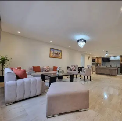 a living room with couches and a table and a kitchen at Modern gated apartment 2 bedroom 2 baths Beachside with pool in Casablanca
