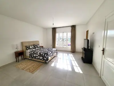 a bedroom with a bed and a television in it at villa dans el mansouria in Mansouria