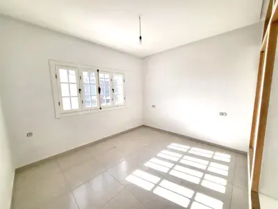 an empty room with white walls and windows at villa dans el mansouria in Mansouria