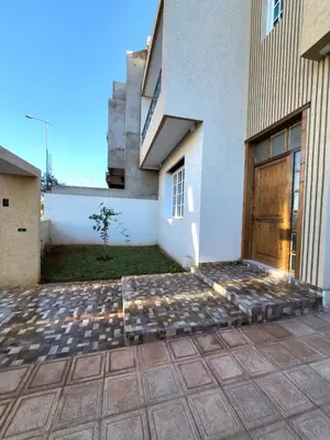a building with a wooden door and a patio at villa dans el mansouria in Mansouria