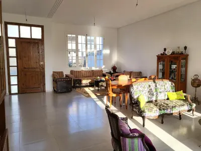 a living room with a table and chairs at villa dans el mansouria in Mansouria