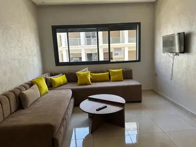 a living room with a couch and a tv at Costa house in Bouznika