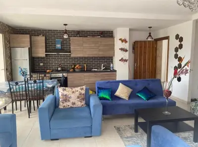 a living room with a blue couch and a kitchen at Puerto banus in Mansouria