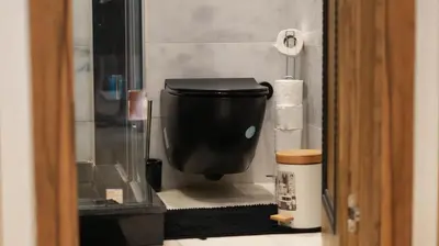 a bathroom with a black toilet and a roll of toilet paper at Central Quiet Spot in Casablanca
