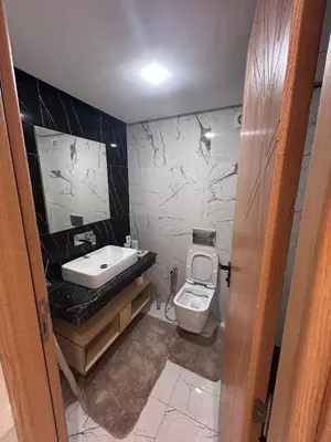 a bathroom with a white toilet and a sink at Appartement élégant et raffiné in Nouaseur