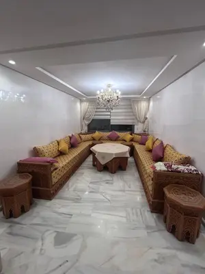 a living room with a couch and a table at Appartement élégant et raffiné in Nouaseur