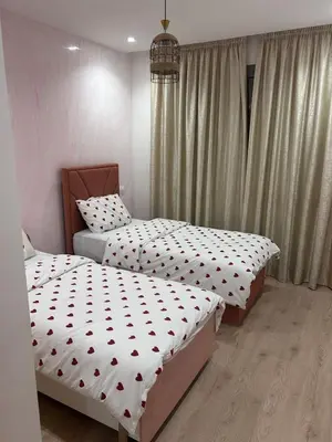 two twin beds in a bedroom with curtains at Appartement élégant et raffiné in Nouaseur