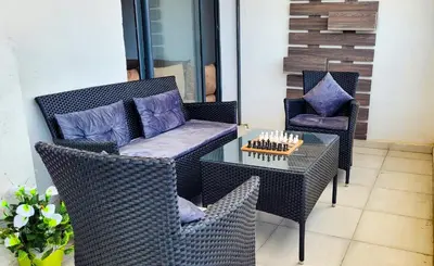 a patio with two chairs and a glass table at البحر والشمس والطبيعه in Pont Blondin