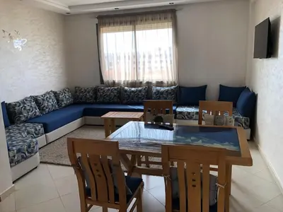 a living room with a table and a blue couch at Sable d or in O Ben Slimane