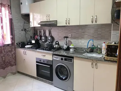 a kitchen with a stove and a washing machine at Sable d or in O Ben Slimane