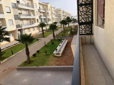 a view of a park with benches and palm trees at Sable d or in O Ben Slimane