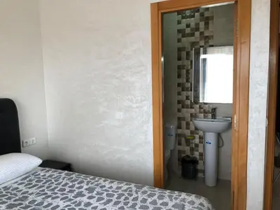 a bedroom with a bed and a sink and a mirror at Sable d or in O Ben Slimane