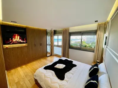 a bedroom with a large bed with a fireplace at ghaouat luxury appart in Casablanca