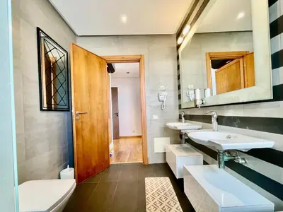 a bathroom with two sinks and a toilet at ghaouat luxury appart in Casablanca