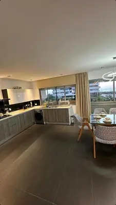 a living room with a table and a kitchen at ghaouat luxury appart in Casablanca