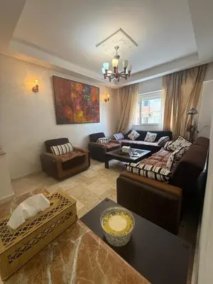 a living room with a couch and a table at Appartement 3 pièces à Mohammédia Proche Marjane, plage & restaurants in Mohammedia