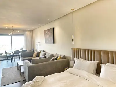 a bedroom with a bed and a living room at 1-Marina Luma oceane-terrasse sur mer in Casablanca
