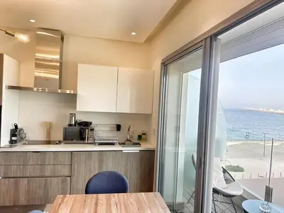 a kitchen with a table and a view of the ocean at 1-Marina Luma oceane-terrasse sur mer in Casablanca