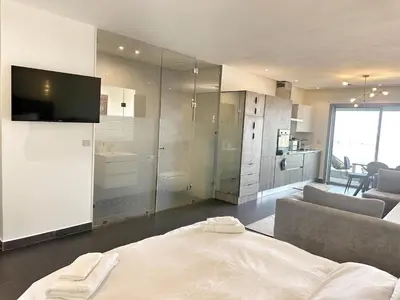 a bedroom with a bed and a tv and a couch at 1-Marina Luma oceane-terrasse sur mer in Casablanca