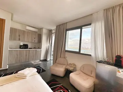 a hotel room with a bed and two chairs at 2-marina Brisa ocean-terrasse sur mer in Casablanca