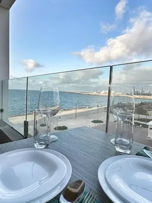 a table with two glasses and a view of the beach at 2-marina Brisa ocean-terrasse sur mer in Casablanca