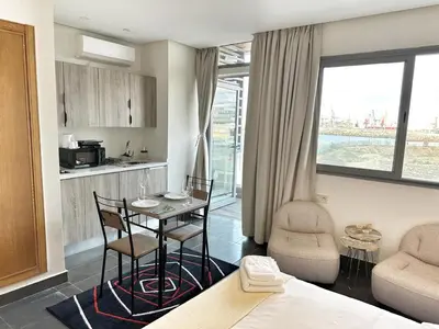 a room with a table and chairs and a kitchen at 2-marina Brisa ocean-terrasse sur mer in Casablanca