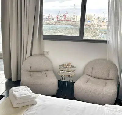 a bedroom with two chairs and a bed and a window at 2-marina Brisa ocean-terrasse sur mer in Casablanca