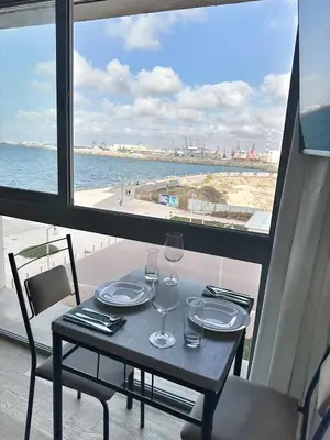 a table with wine glasses and a view of the beach at 3-marina Serena ocean-studio chic vue mer in Casablanca