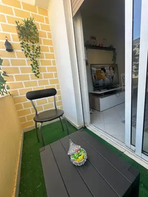 a chair and a bowl of candy on a table on a patio at Apprt 2min de la Gare,Wi-Fi Fibre, Netflix ,PS4 in Settat