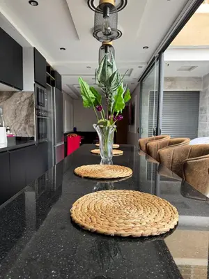 a kitchen with a glass table with a vase on it at Apartment with pool view in Mansouria