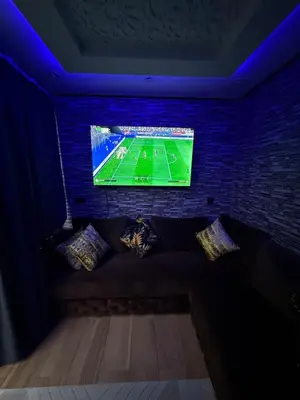 a room with a couch with a tv on a brick wall at Apartment with pool view in Mansouria