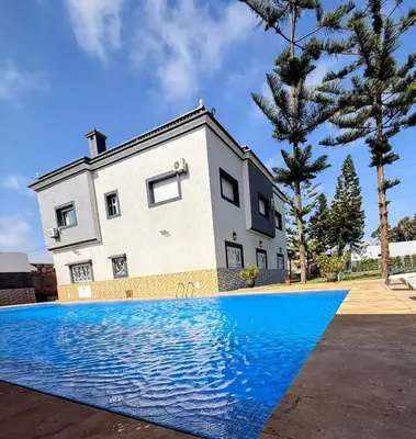 a house with a swimming pool in front of it at Villa Royale Prestige Safaa in Dar Bouazza
