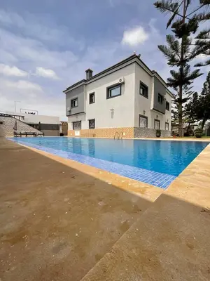 a large swimming pool in front of a house at Villa Royale Prestige Safaa in Dar Bouazza