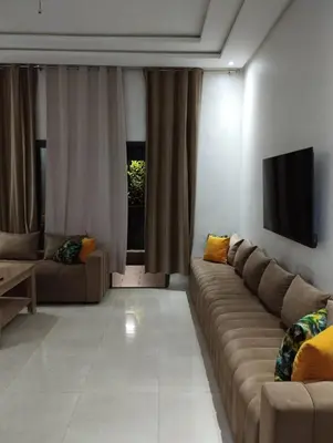 a living room with a couch and a flat screen tv at Appartement à louer à Bouznika avec piscine in Bouznika