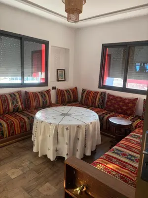 a living room with a couch and a table in it at Cozy apartment near the airport in Deroua
