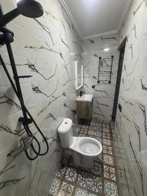 a bathroom with a toilet and a sink at Cozy apartment near the airport in Deroua