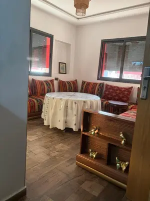 a living room with a table and a couch at Cozy apartment near the airport in Deroua