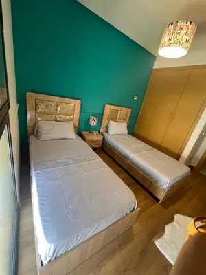 two beds in a room with a green wall at Appartement Élégance Cosy in Rabat