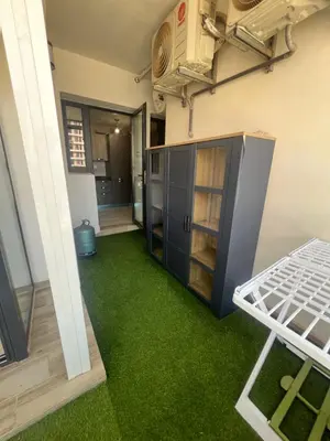 a room with green carpet and a kitchen with an open door at Appartement Élégance Cosy in Rabat